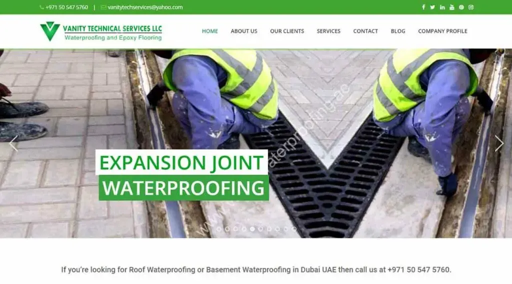 Two construction workers wearing safety vests are installing waterproofing materials on an expansion joint, with visible tools and a partially paved area, highlighting waterproofing services.