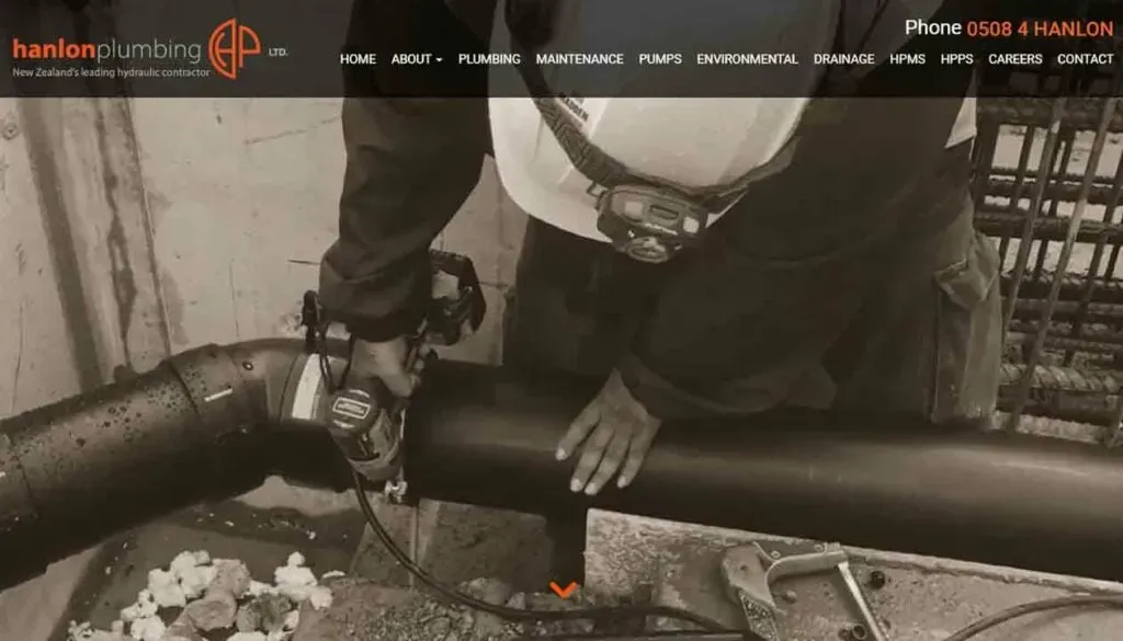 A worker in protective gear operates a power tool on a large black pipe, emphasizing plumbing services provided by a New Zealand hydraulic contractor.