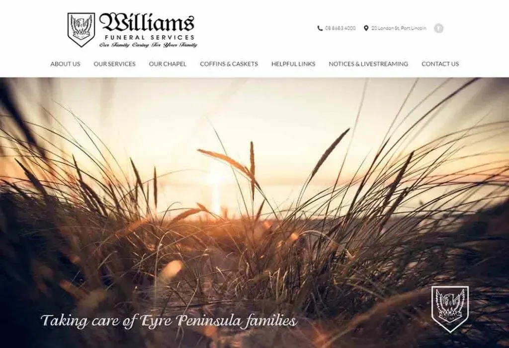 Sunset view over a field with tall grasses on a funeral services website featuring navigation links and contact information.