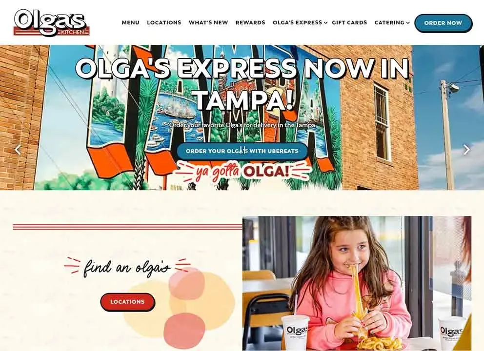 A young girl with long brown hair enjoys a meal at Olga's Express in Tampa, featuring a sandwich and fries, set against a bright and colorful interior with promotional signage for Olga's.