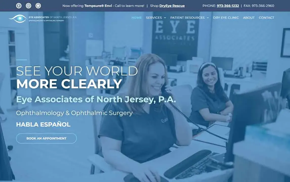 Two smiling dental office staff members work at a reception desk with computers, surrounded by calming blue decor and informative signage; text highlights ophthalmology services available in both English and Spanish.