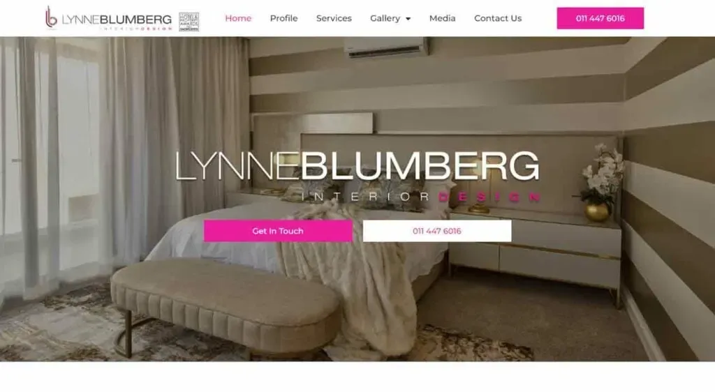A cozy, elegantly designed bedroom features a large bed with a cushioned headboard and neutral linens, complemented by striped accent walls and a bench at the foot of the bed, creating a sophisticated and inviting atmosphere.