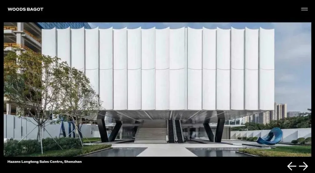 A modern architectural building in Shenzhen features a unique design with white, angular panels and elevated structure, surrounded by greenery and urban elements.