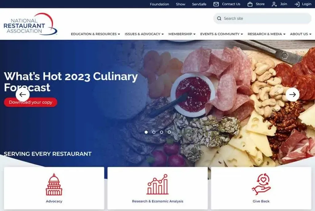 Homepage of the National Restaurant Association featuring a 2023 culinary forecast with a charcuterie board display, including meats, cheeses, fruits, and spreads.
