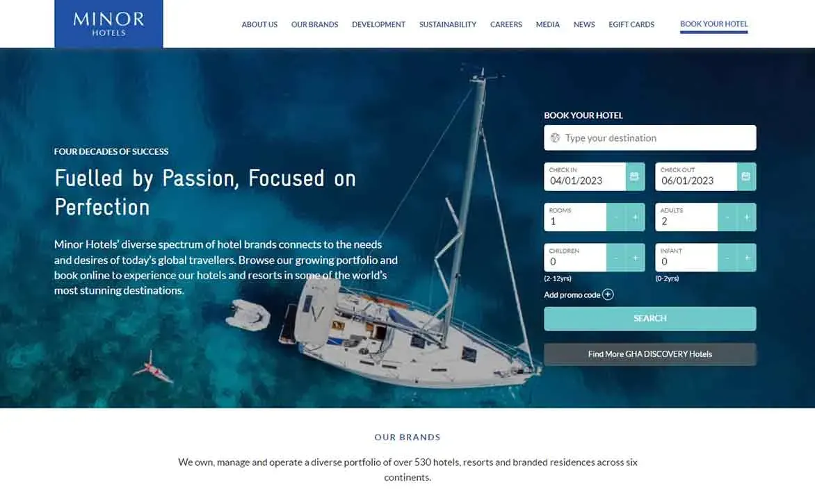 Sailing yacht anchored on pristine blue water featured in a promotional website image for Minor Hotels, showcasing luxury travel and booking options with a focus on exceptional hospitality.