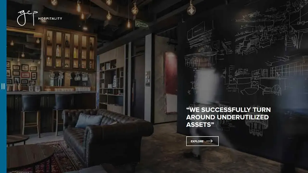 A modern, dimly lit lounge with leather seating, exposed brick, and a chalkboard wall featuring architectural sketches, embodying a sophisticated yet cozy ambiance.