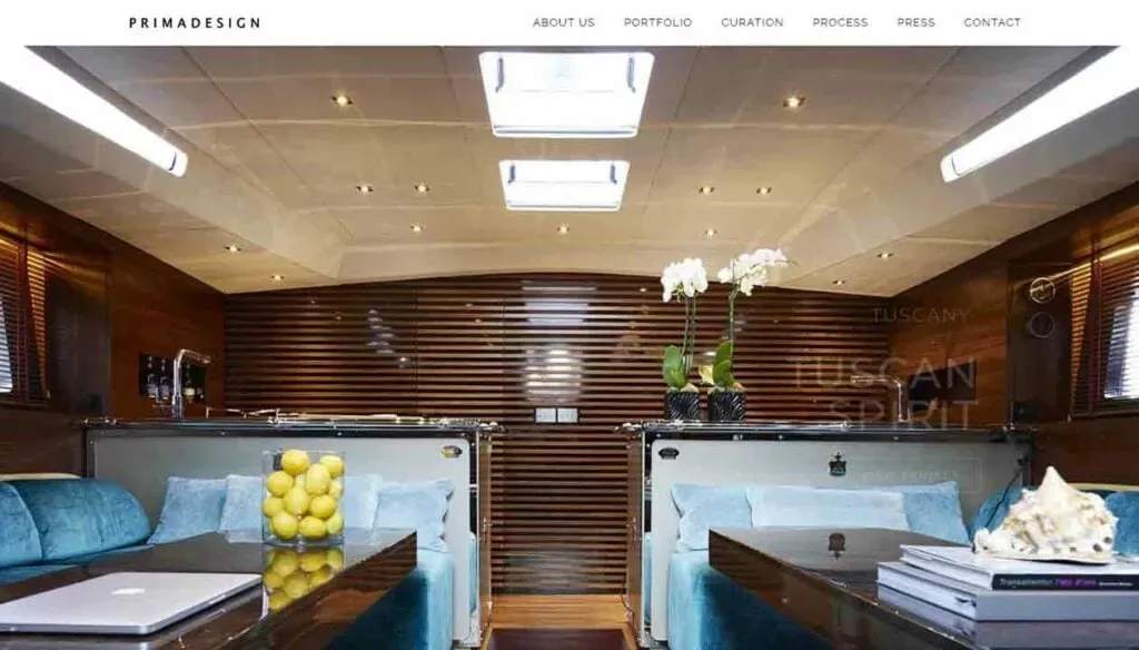 Luxurious yacht interior showcasing elegant wood paneling, plush turquoise seating, a table centerpiece with a bowl of fresh lemons, and potted orchids, all under soft, ambient lighting.