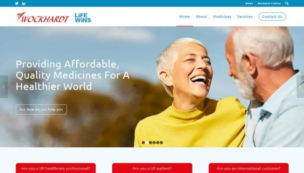 The image shows an elderly man and woman smiling warmly at each other with a background text that reads "Providing Affordable, Quality Medicines For A Healthier World" displayed on a company's healthcare-themed website with navigation links and a call-to-action button.
