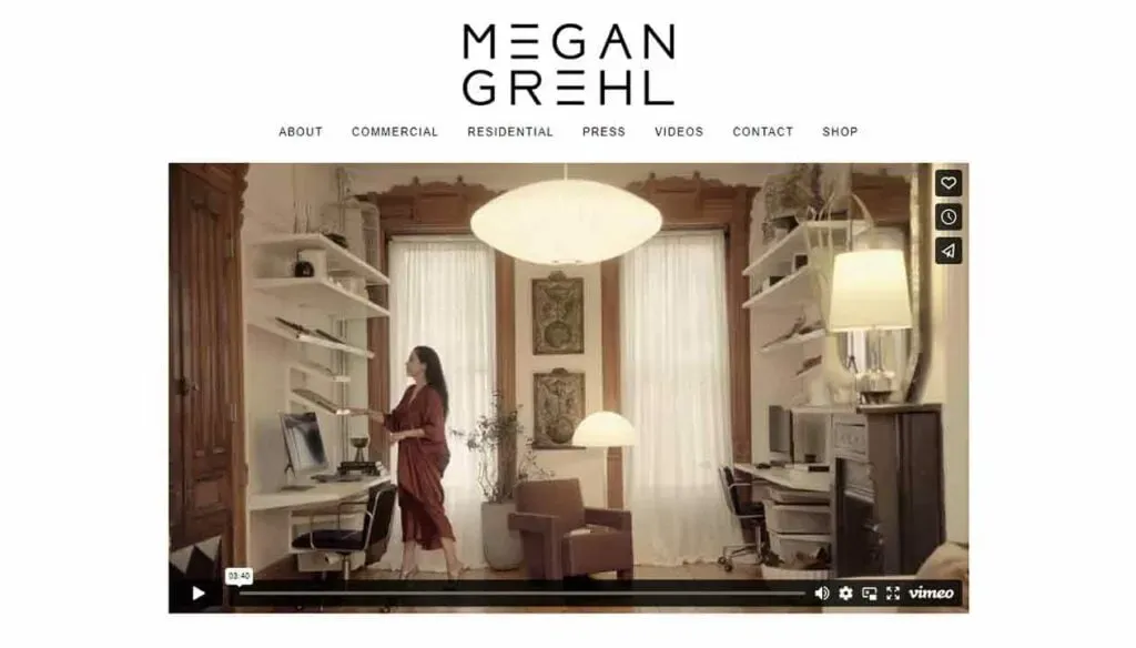 A modern home office with built-in white shelves, a large wooden table, and a stylish pendant lamp, featuring floor-to-ceiling windows with sheer curtains, creating an airy and sophisticated atmosphere.