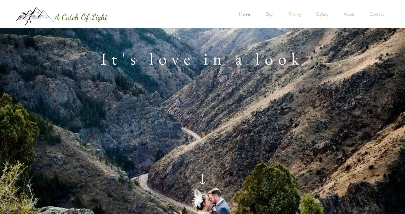 A couple embraces on a rocky mountain landscape with a winding road, under the slogan "It's love in a look," highlighting the serene and romantic outdoor setting.