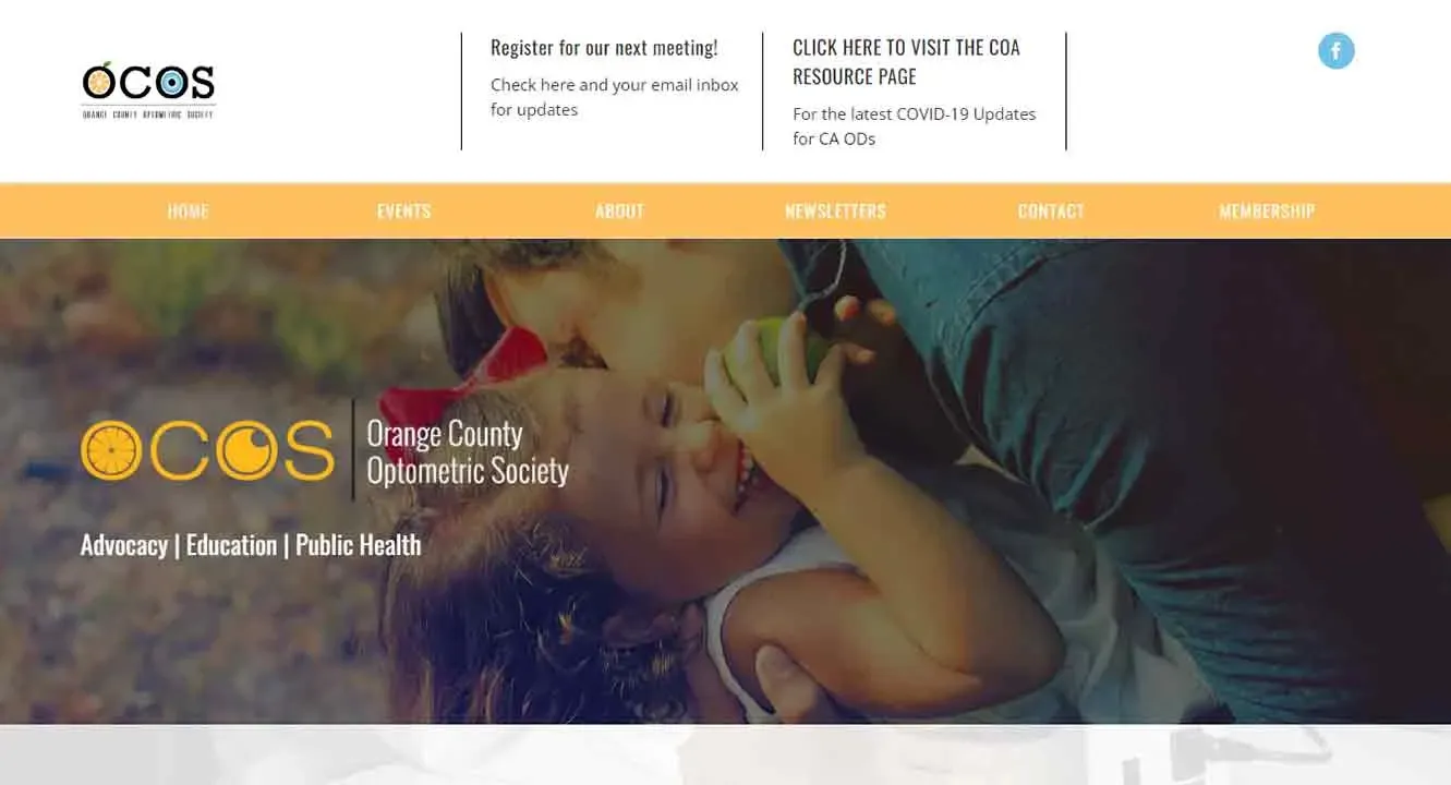 A child in a white dress is playfully held and kissed by an adult on the grass, with a banner for the Orange County Optometric Society displayed above, featuring links to events, newsletters, and contact information.