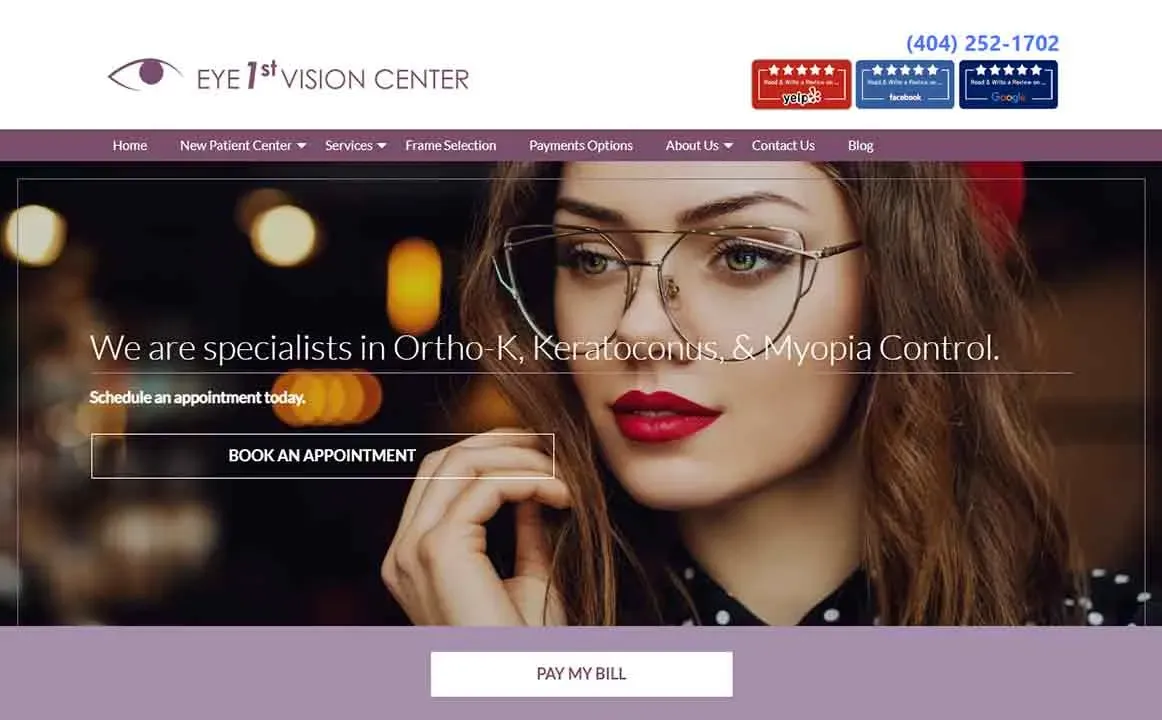A woman with long, wavy hair and wearing stylish large eyeglasses is touching her hair, set against a blurred background, featured on a website for Eye 1st Vision Center, highlighting their expertise in Ortho-K, Keratoconus, and Myopia Control with options to book an appointment.