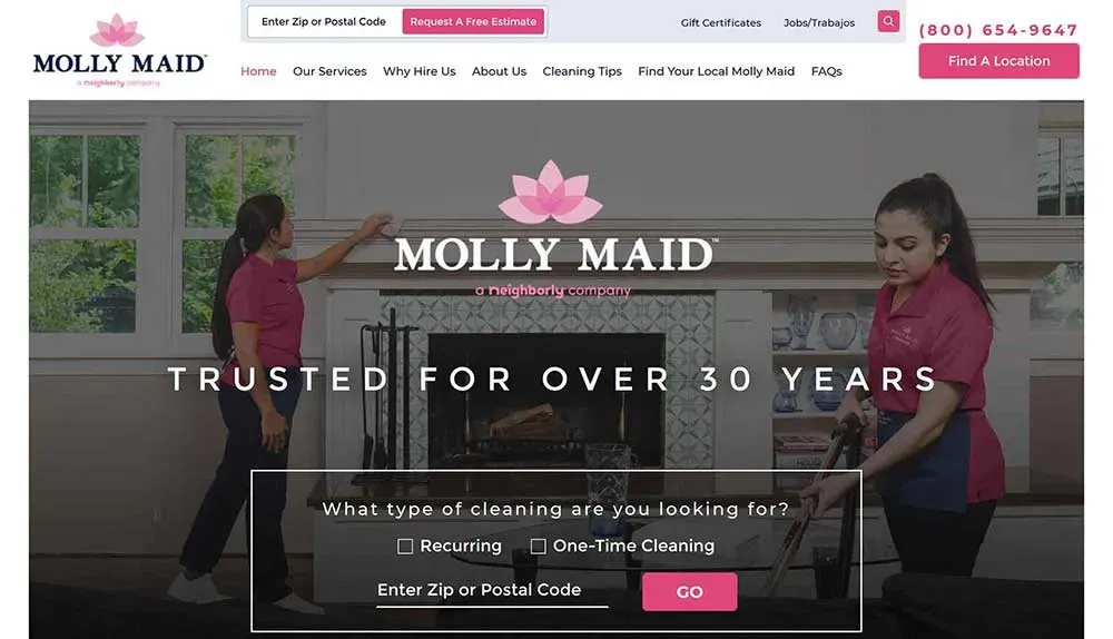 A woman in a Molly Maid uniform cleans a residential fireplace while another woman stands nearby, showcasing professional home cleaning services and trust built over 30 years.
