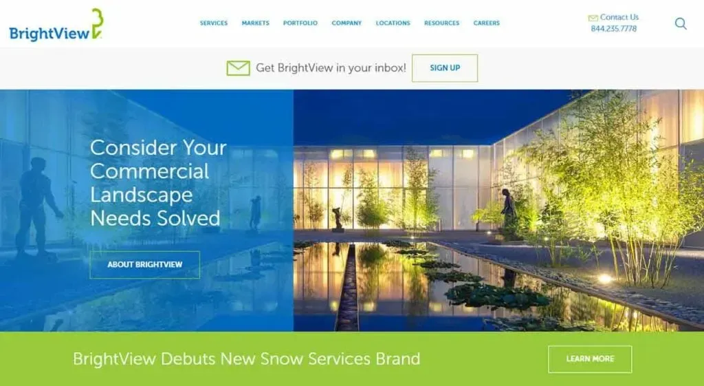 The image shows a modern, well-lit office building at dusk, surrounded by expertly landscaped gardens with a reflecting pool in the foreground, featured on BrightView's website, promoting their commercial landscaping solutions.