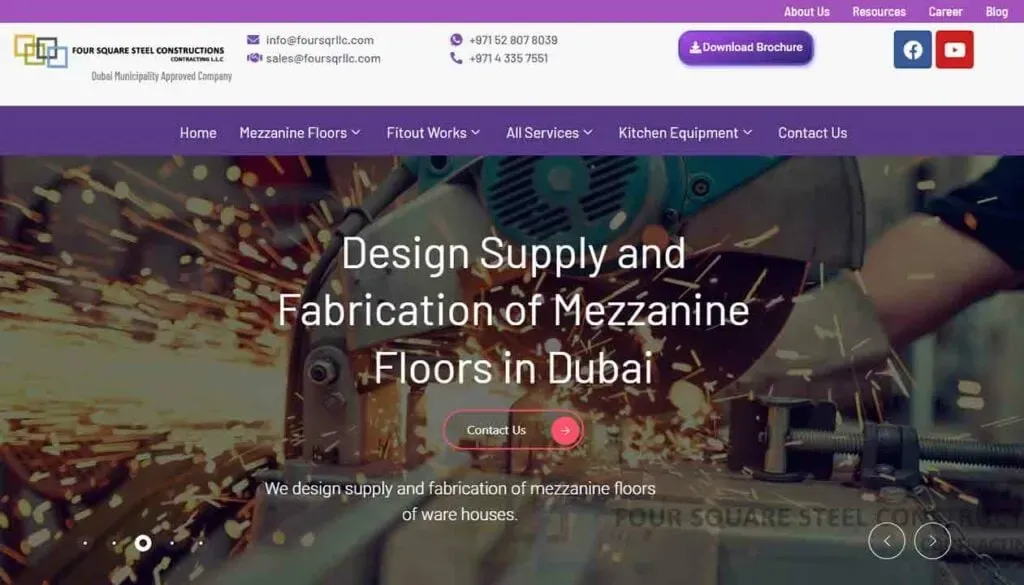 The homepage of a construction company website showcases industrial machinery in action with sparks flying, highlighting services for design and fabrication of mezzanine floors in Dubai with contact options and navigation links.