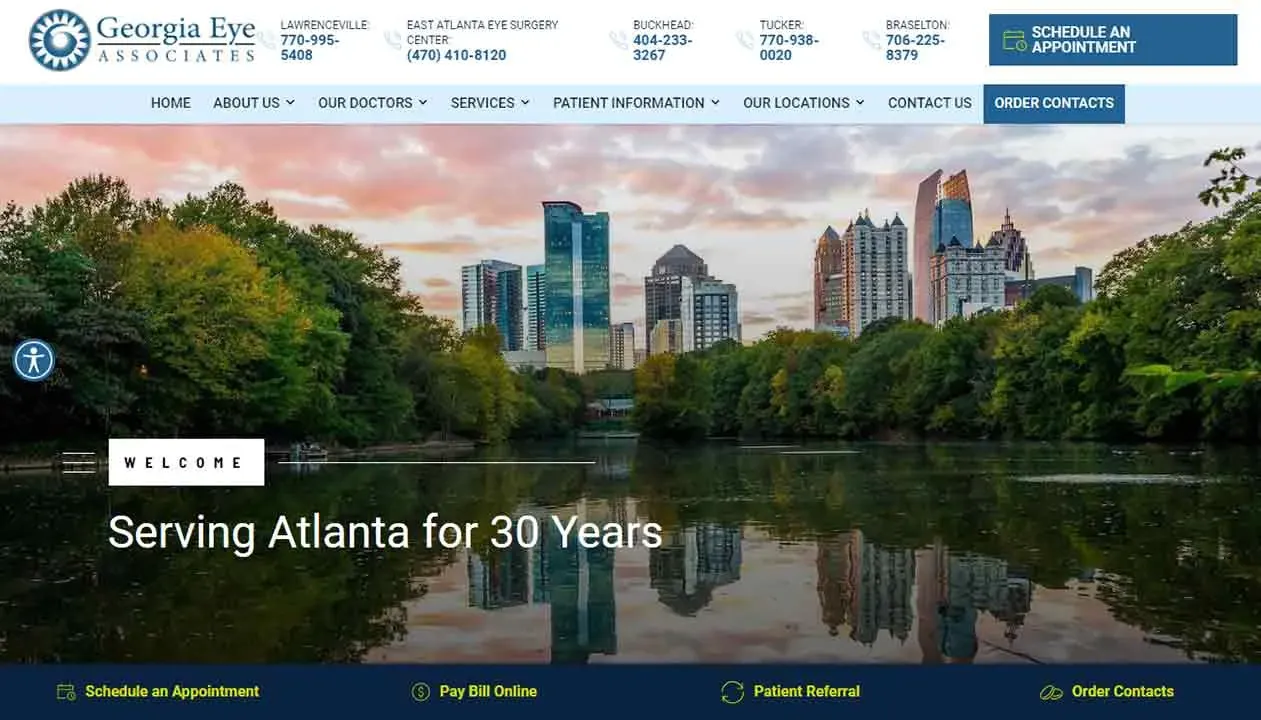 City skyline of Atlanta with modern skyscrapers reflecting on a serene lake, surrounded by lush greenery under a clear sky at sunset.