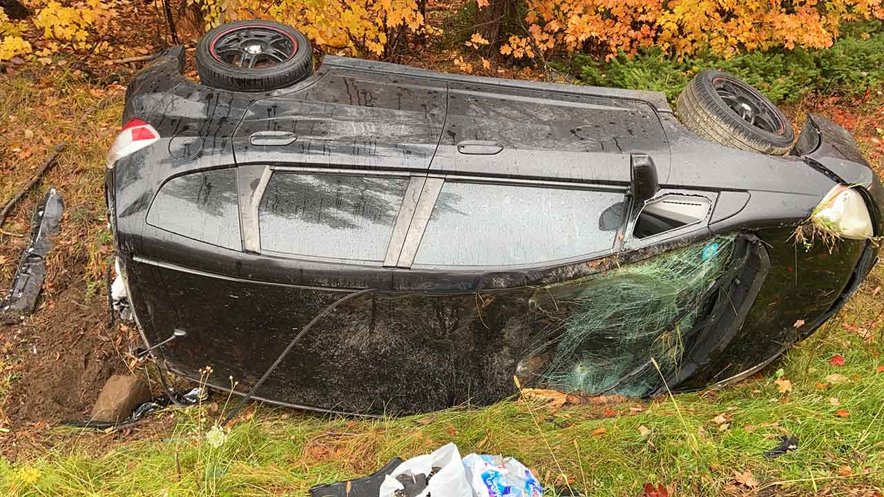Auto destrozado siendo sacado de la zanja
