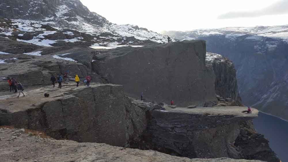 Standing on the Trolltunga rock ledge above the fjord